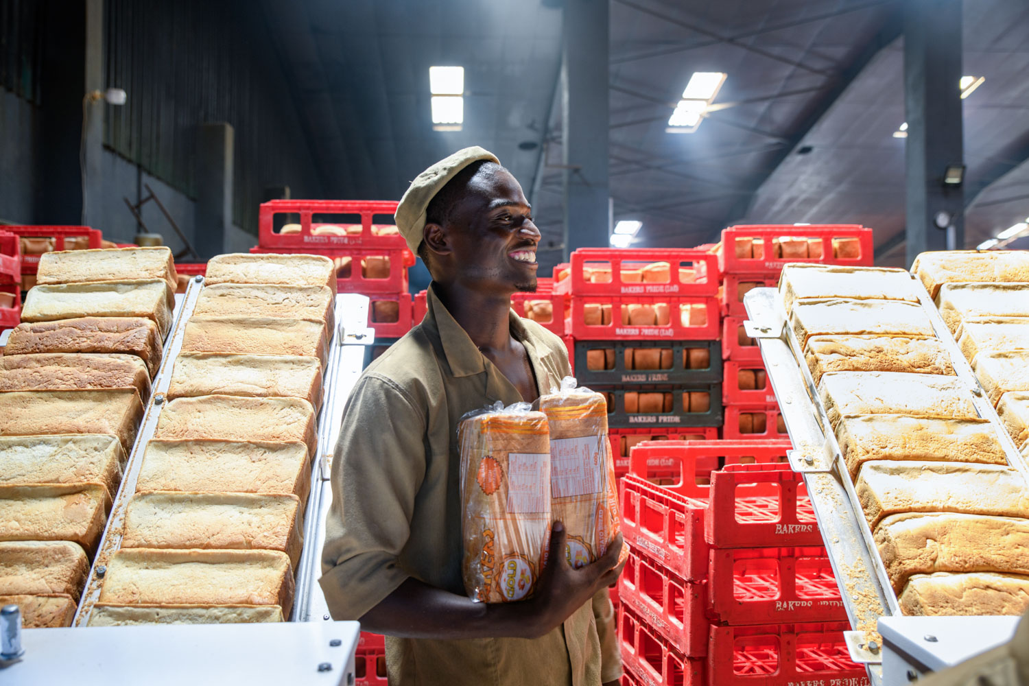 Happy worker at Olympic Bakery holding bread | Malawi